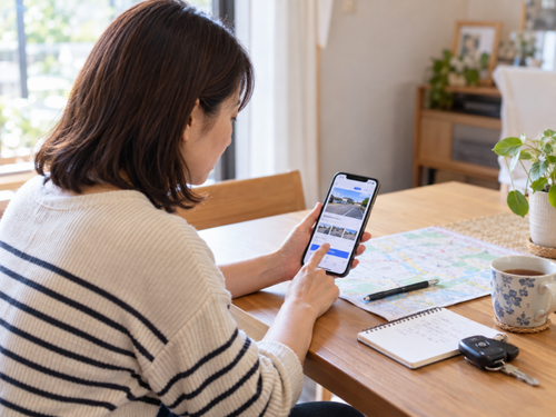 花火大会の予約駐車場についてスマートフォンで利用条件を確認する様子