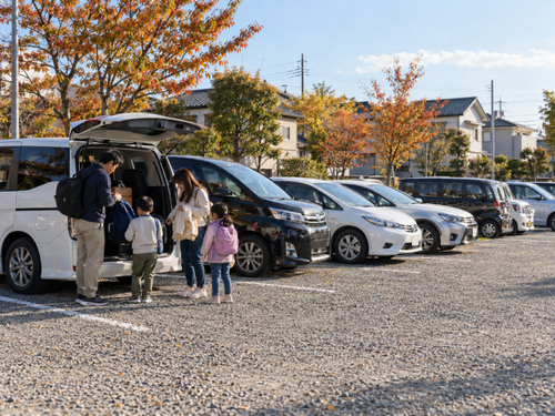 花火大会の臨時駐車場で車を停めて会場へ向かう準備をする家族